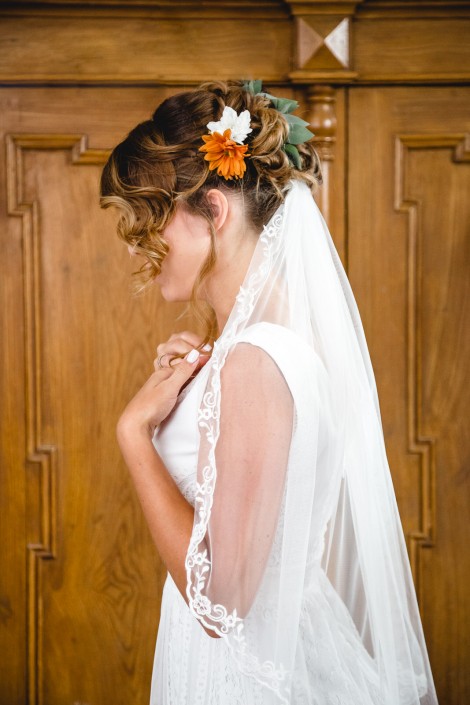Braut im Hochzeitskleid mit Schleier und Blumen im Haar