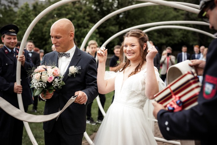 Braut und Bräutigam mit Feuerwehr bei Hochzeitsbrauch