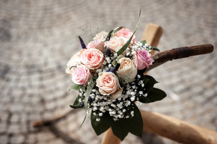 Brautstrauss mit Rosen auf Sägebock mit Säge