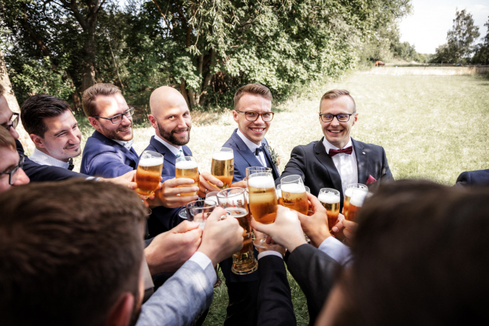 Kumpels des Bräutigam stoßen zusammen mit einem Glas Bier an