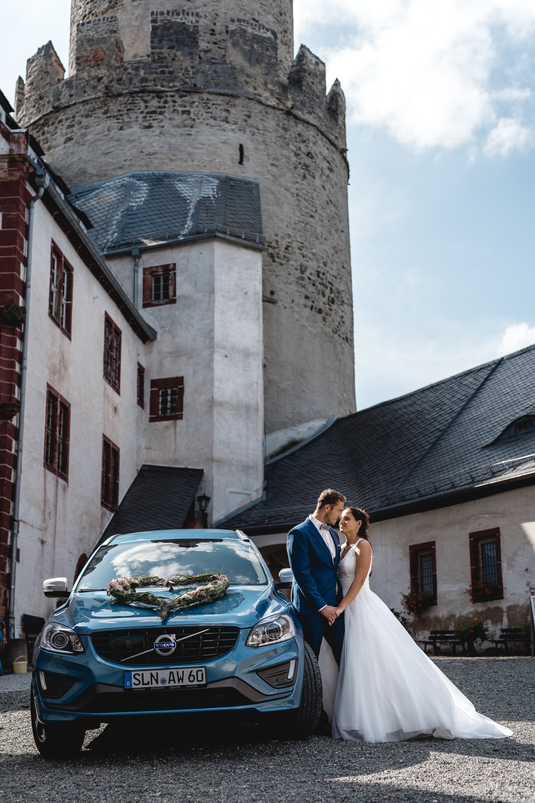 Hochzeitspaar mit Brautauto Volvo geschmückt mit Autoschmuck auf Osterburg Weida beim Paarshoot